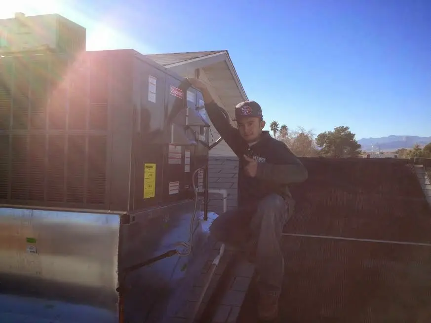 HVAC technician performing Air Duct Cleaning on a rooftop unit in Newport